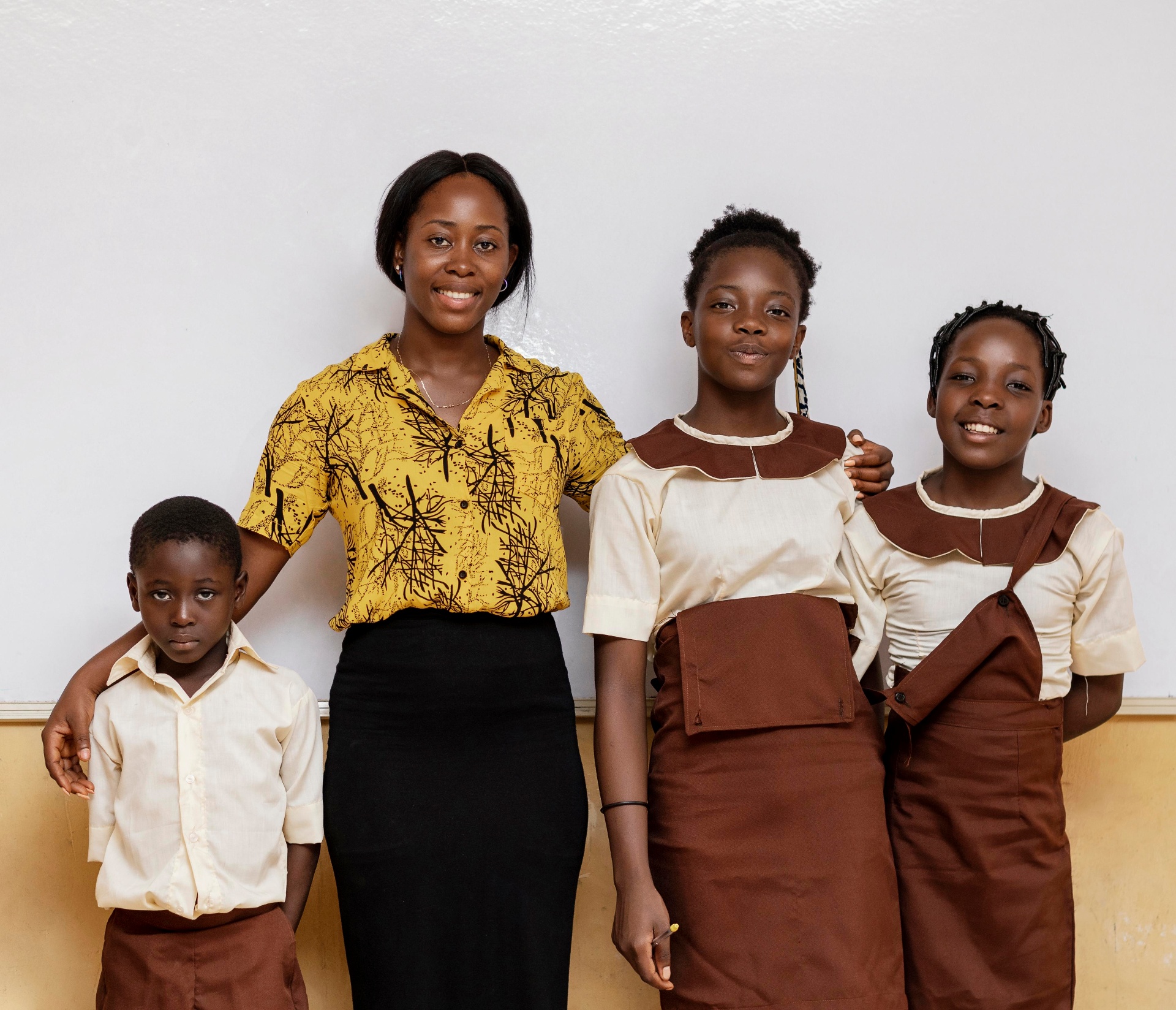 A teacher standing with three of her students in a classroom