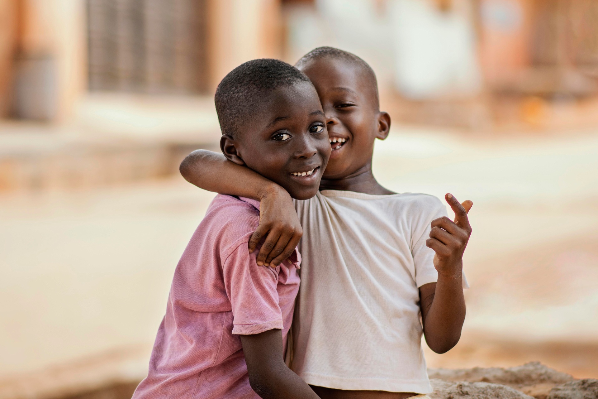Two young boys hugging and smiling warmly